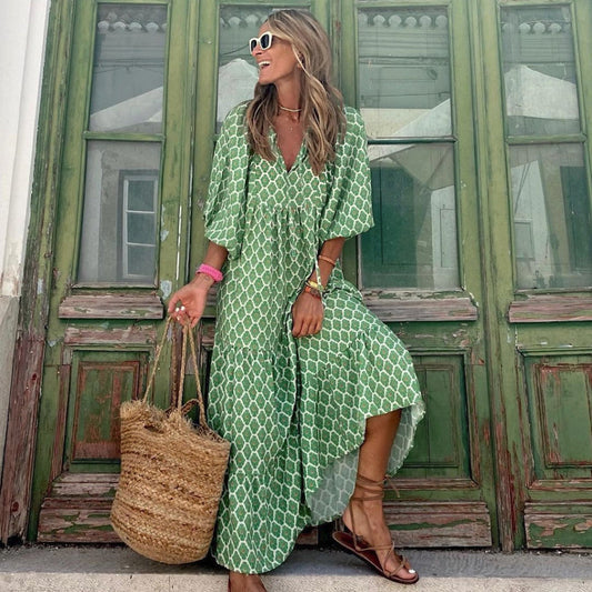 Woman in a green patterned dress standing in front of a green door.
