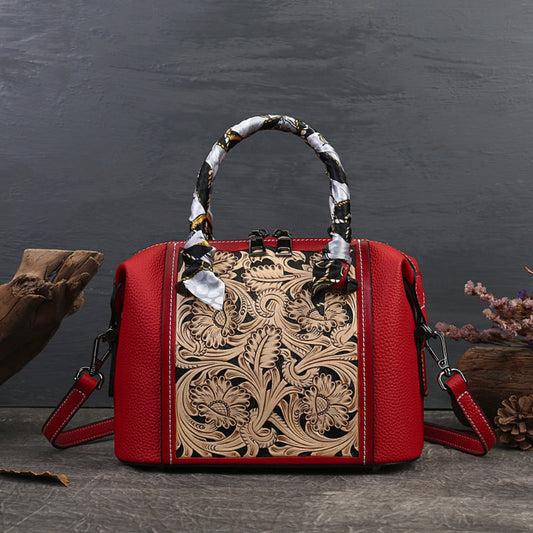 Red handbag with intricate leather design on a dark background