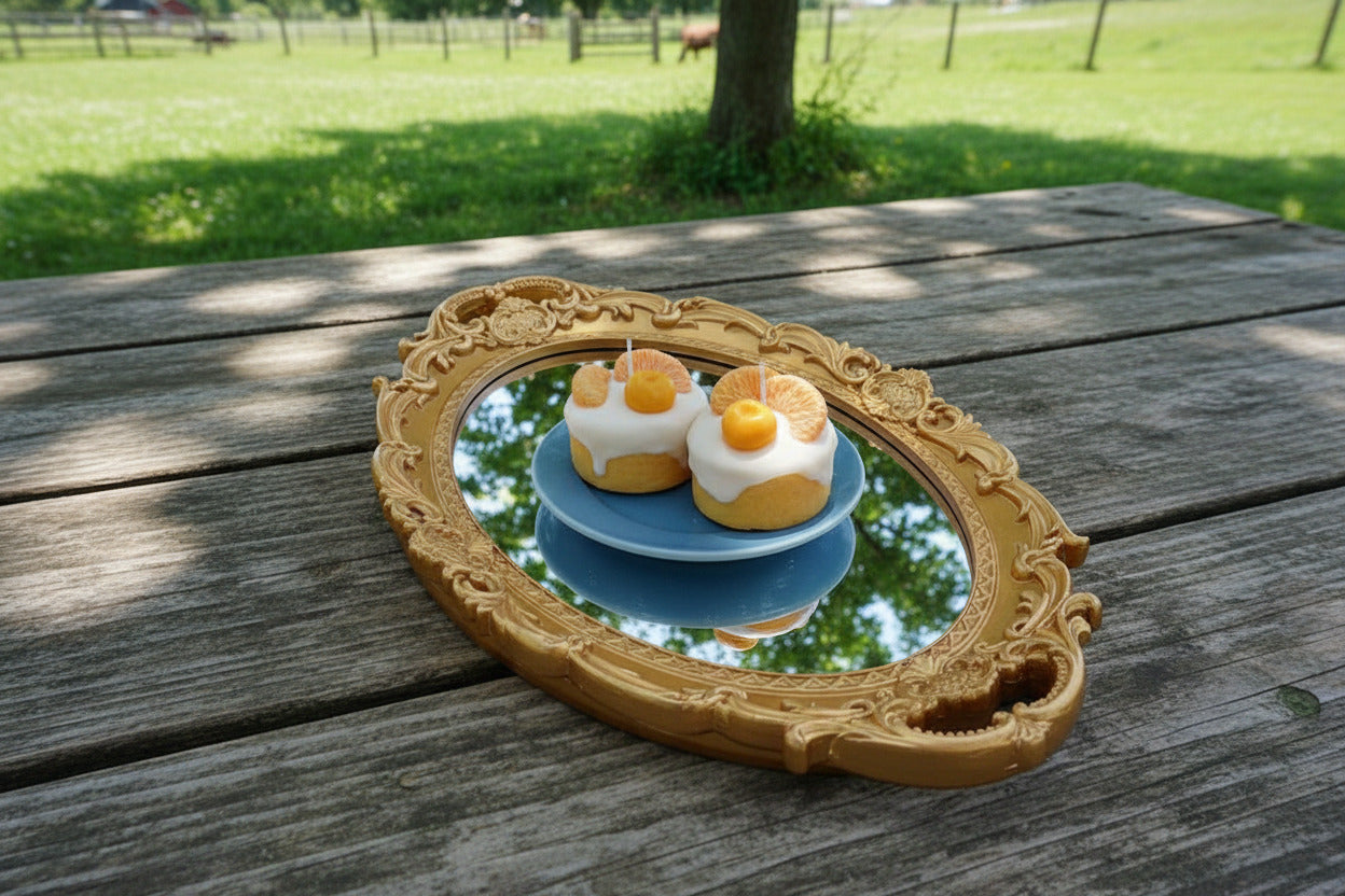 Two dessert items with orange slices in a decorative gold frame.