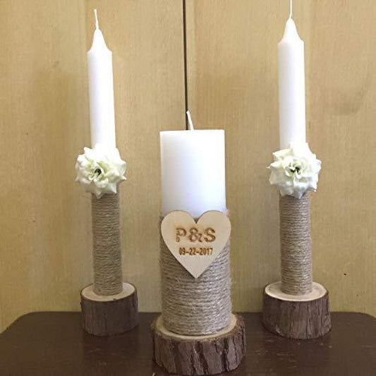 Three candles on wooden stands with floral decorations and a heart-shaped plaque on a beige background