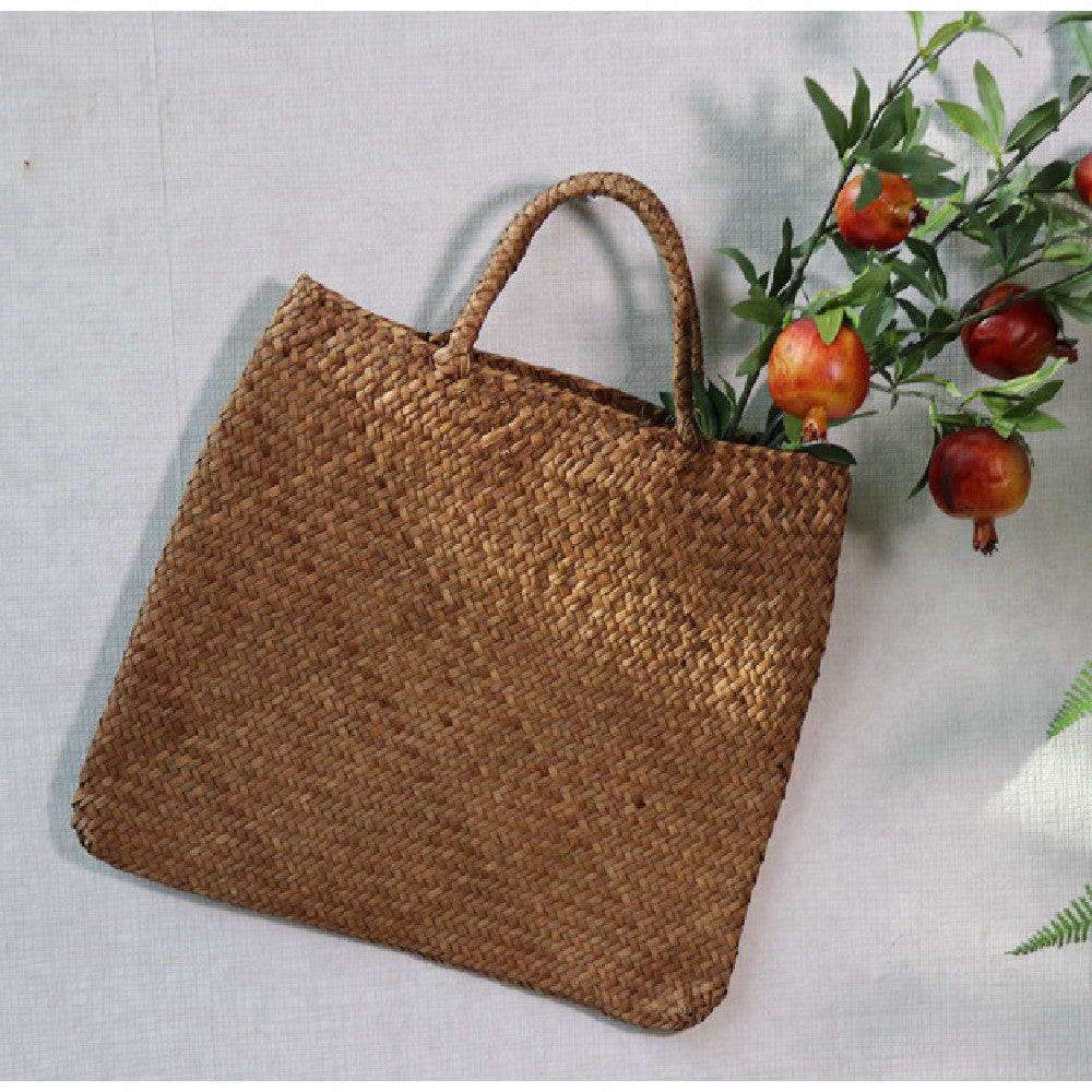 Woven brown bag with handles on a light gray background