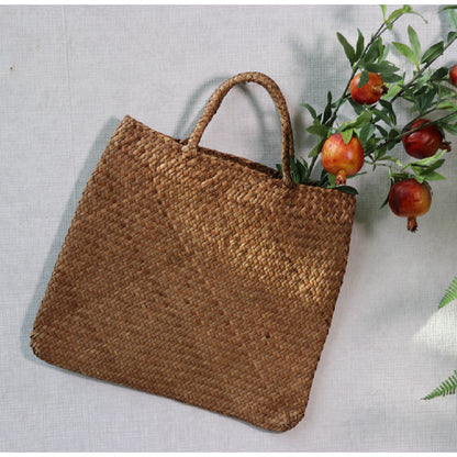 Woven brown bag with handles on a light gray background