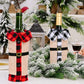 Two wine bottles wrapped in festive plaid and burlap covers on a table with Christmas decorations.