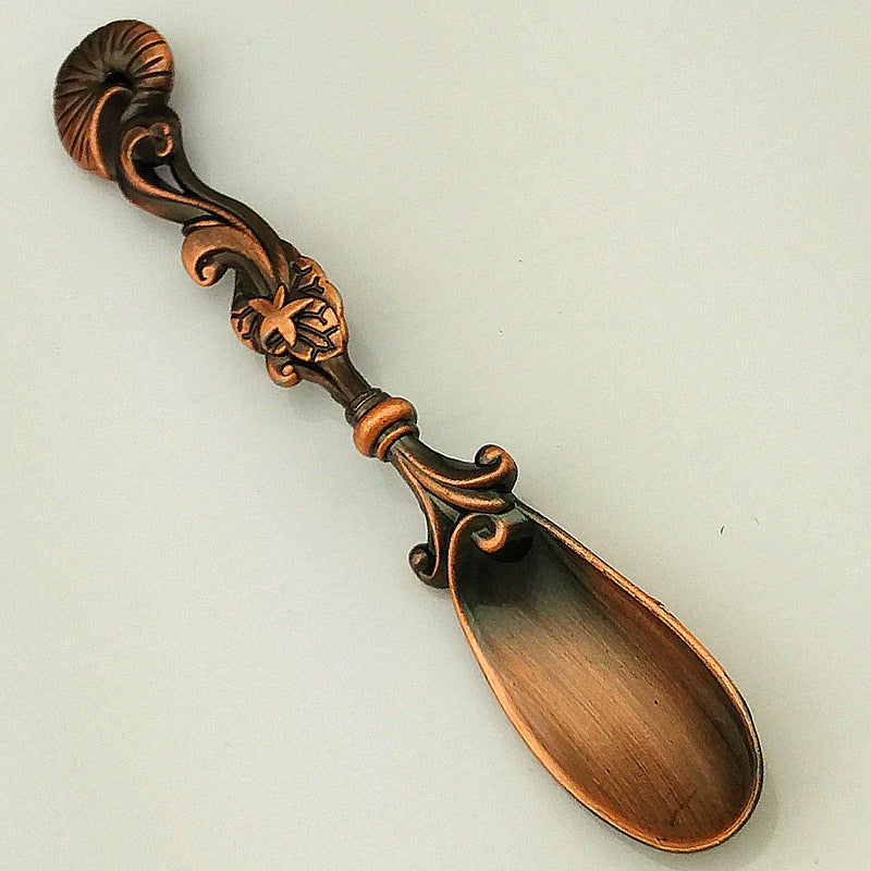 Decorative copper spoon on a light gray background