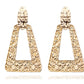 Gold triangle-shaped earrings on a white background