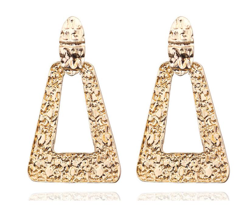 Gold triangle-shaped earrings on a white background