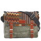Multicolored patterned bag with gray strap and brown leather accents on a white background