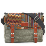 Multicolored patterned bag with gray strap and brown leather accents on a white background