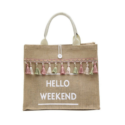 Jute bag with tassels and 'Hello Weekend' text on a white background