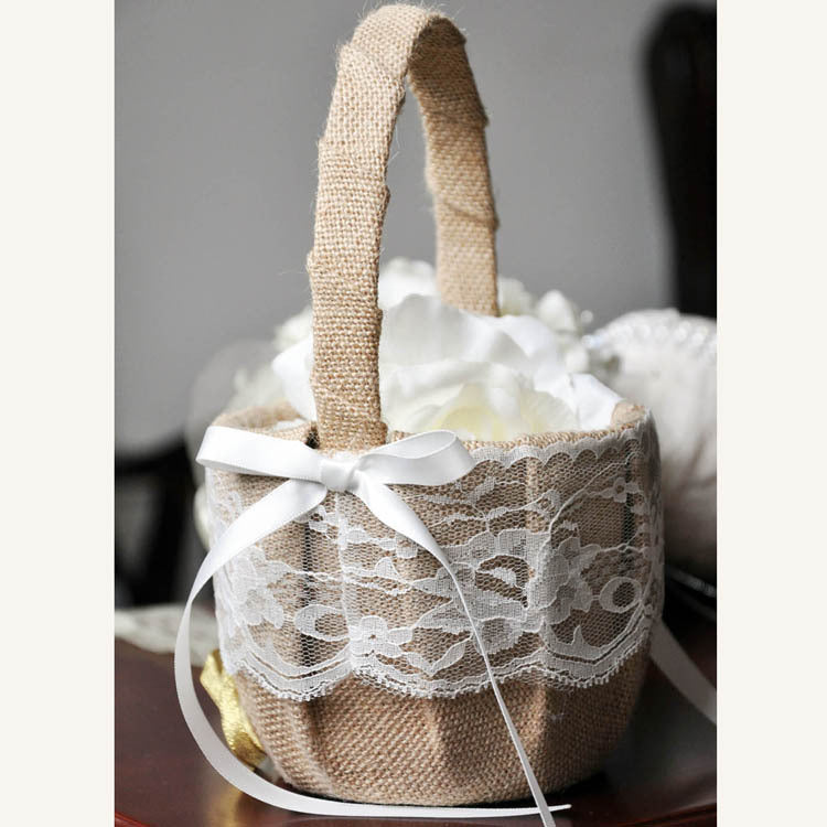 Decorative basket with lace detailing and a white ribbon on a neutral background