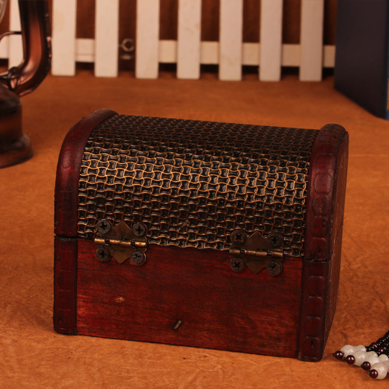 Wooden treasure chest with metal mesh lid on a wooden surface
