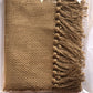 Textured brown fabric with tassels on a white background