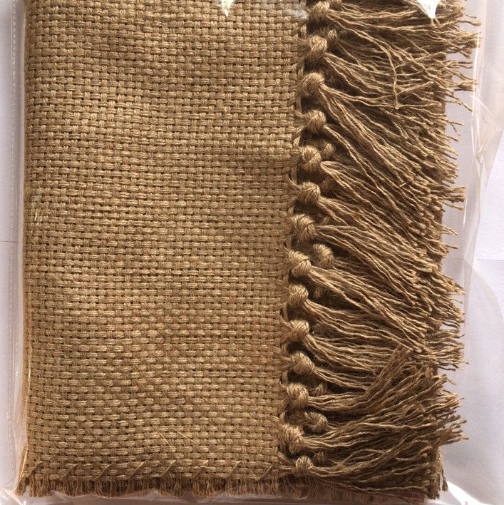 Textured brown fabric with tassels on a white background
