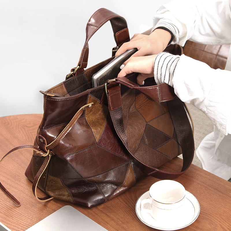Brown patchwork handbag on a wooden surface with a cup and saucer.