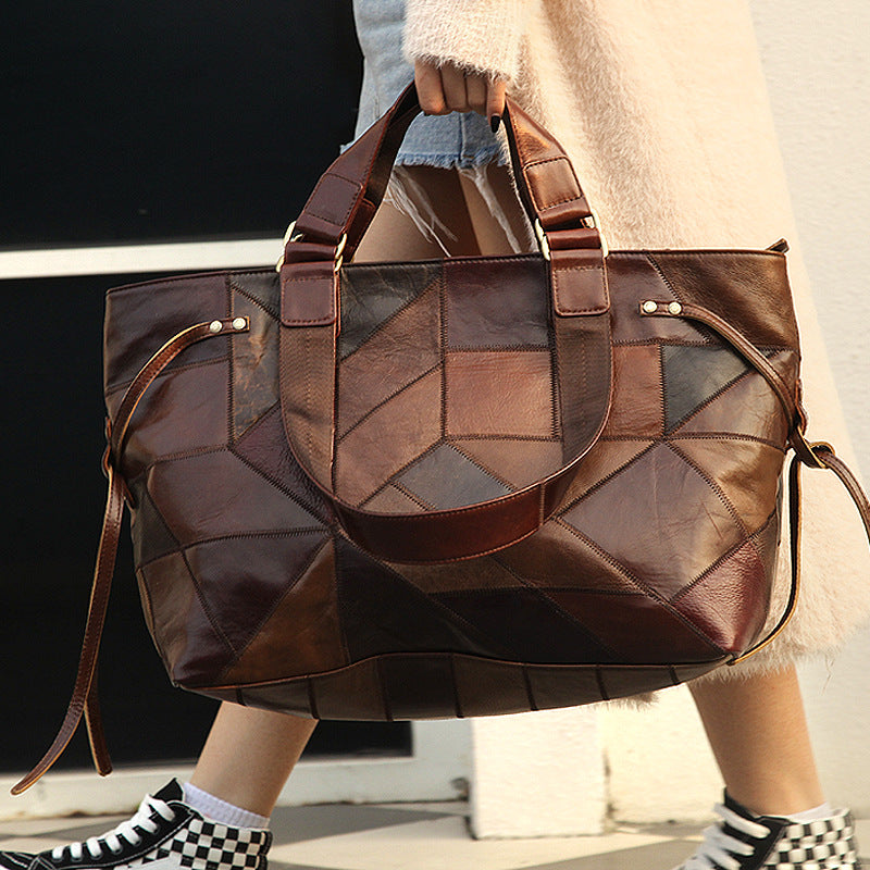 Brown patchwork handbag held by a person with a blurred background