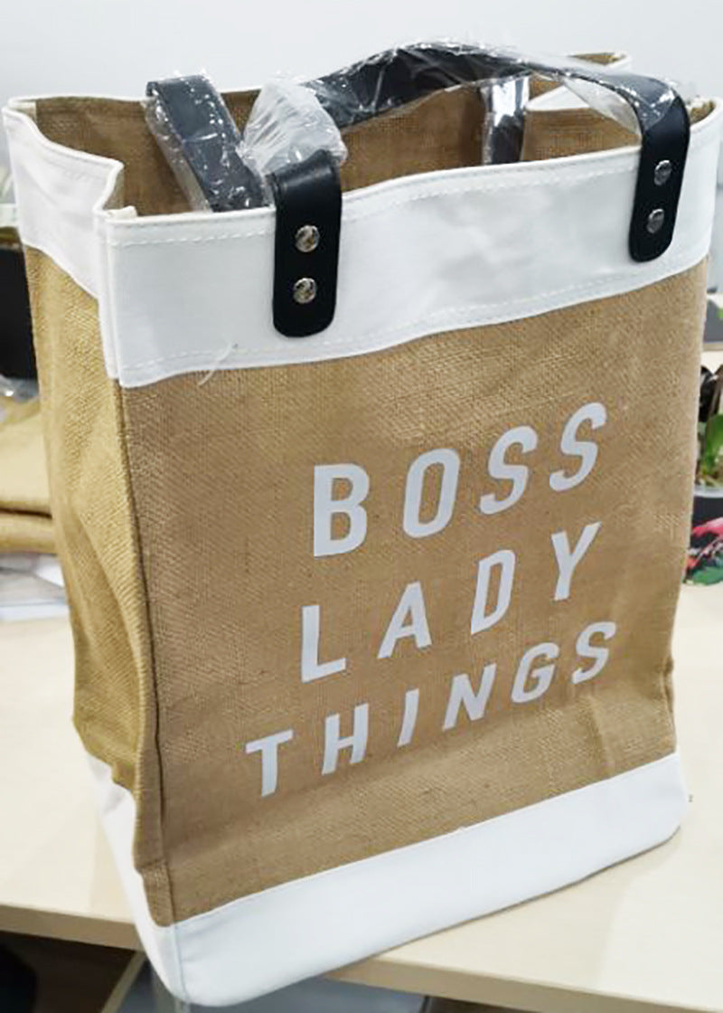 Brown tote bag with 'BOSS LADY THINGS' text on a white background