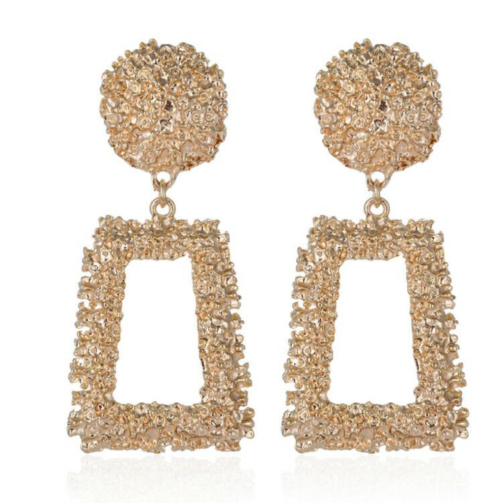 Gold earrings with spherical top and rectangular frame on a white background