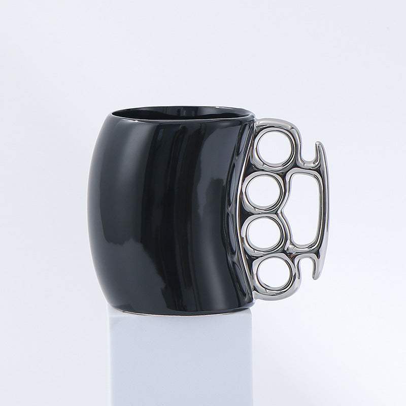 Black mug with a silver knuckle-duster handle on a white background