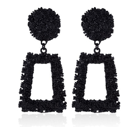 Black textured earrings with square drops on a white background