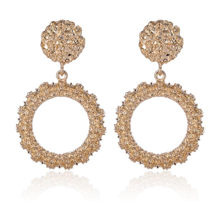 Gold hoop earrings with intricate designs on a white background