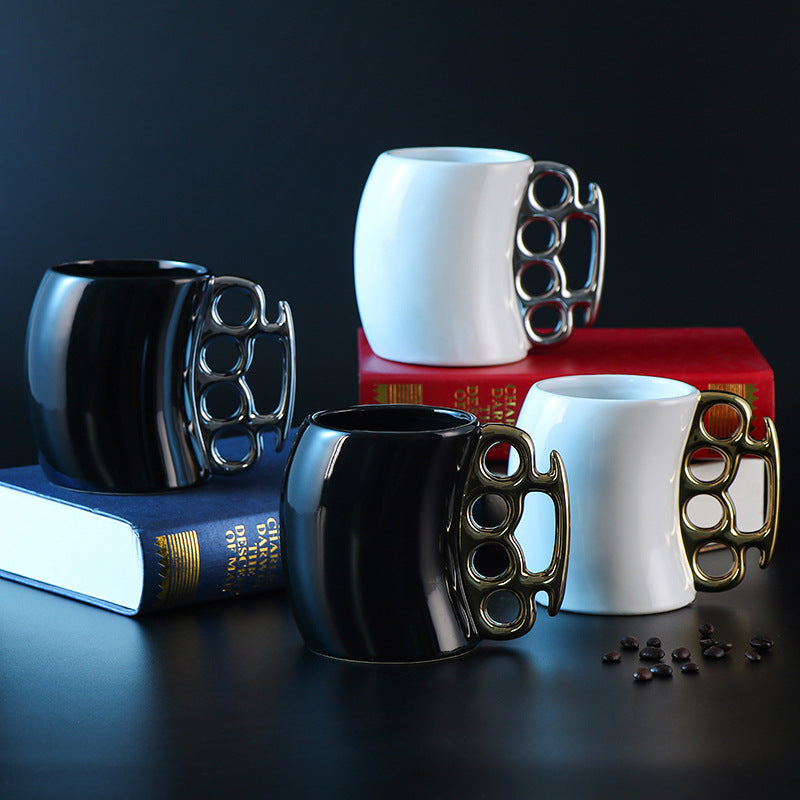 Four mugs with knuckle duster handles on books against a dark background