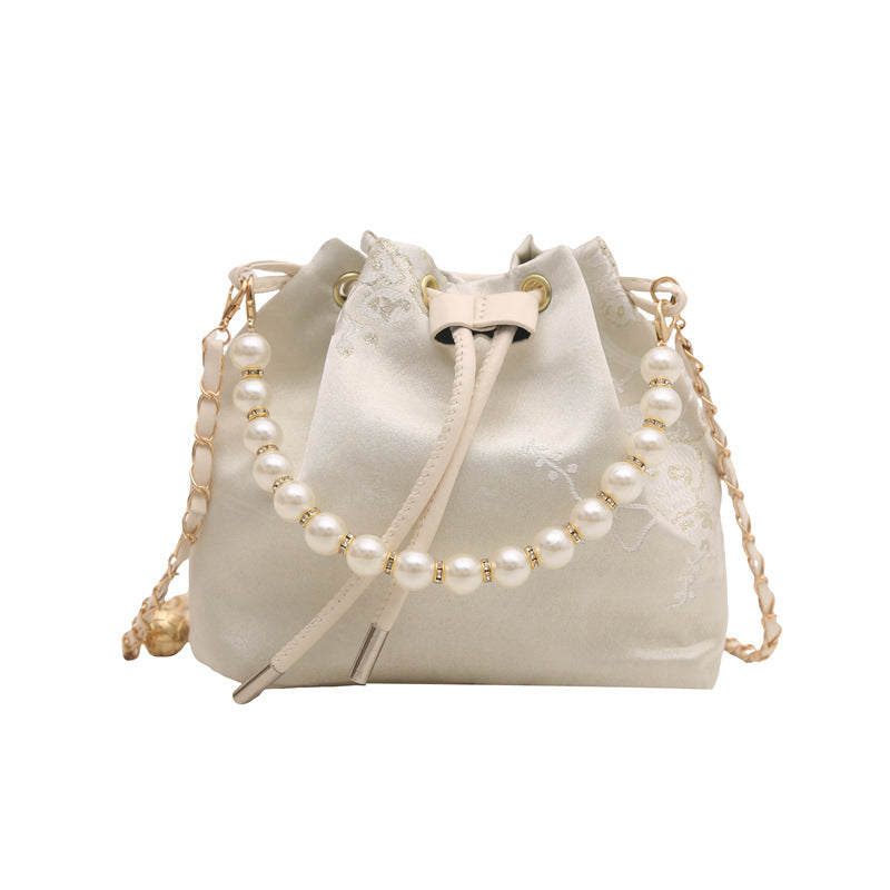 White drawstring bag with pearl chain on a white background