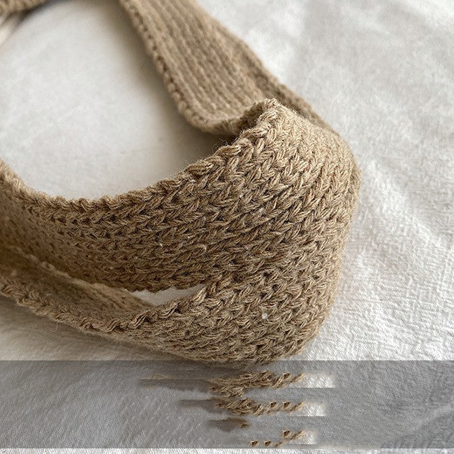 Close-up of a brown knitted headband on a white background