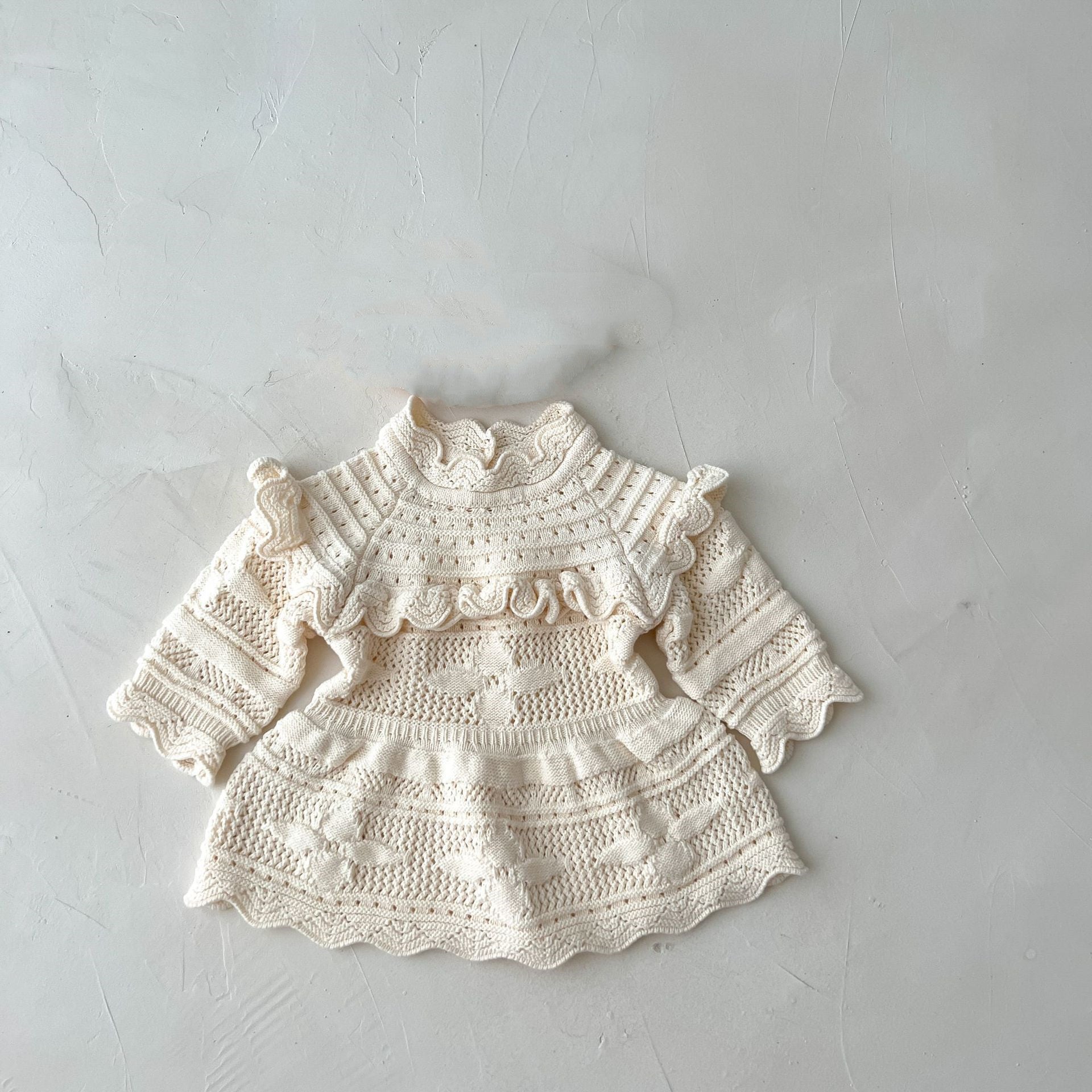 Knitted baby dress on a light gray background