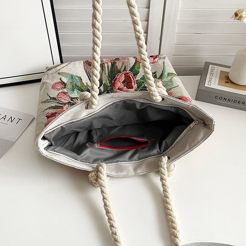 Floral-patterned bag with rope handles on a white surface