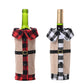 Two wine bottles wrapped in plaid and burlap covers on a white background