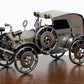 Metallic model of an old-fashioned car on a wooden surface