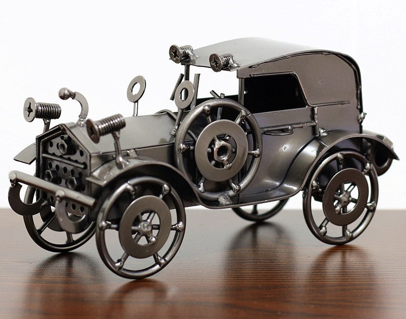 Metallic model of an old-fashioned car on a wooden surface