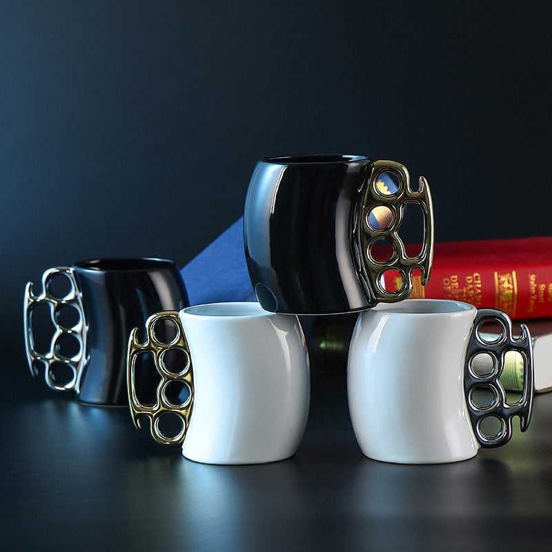 Four mugs with knuckle duster handles on a dark surface