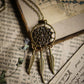 Bronze dreamcatcher necklace on an old book page