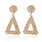 Gold triangle-shaped earrings on a white background