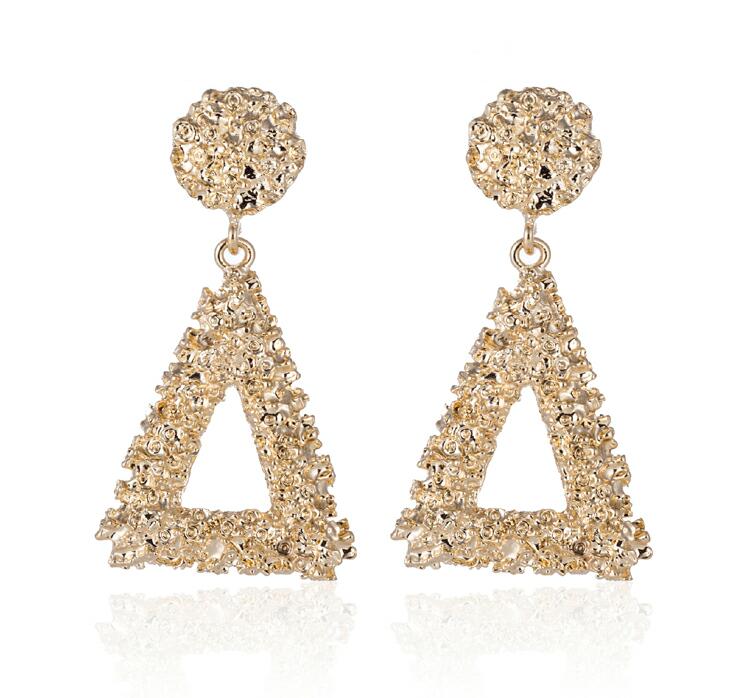 Gold triangle-shaped earrings on a white background