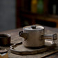 Traditional ceramic teapot and cup on a wooden tray with a blurred background