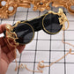 Sunglasses with gold monkey designs on a checkered background