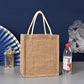 Brown jute bag with a bottle of water on a gray surface against a blue background