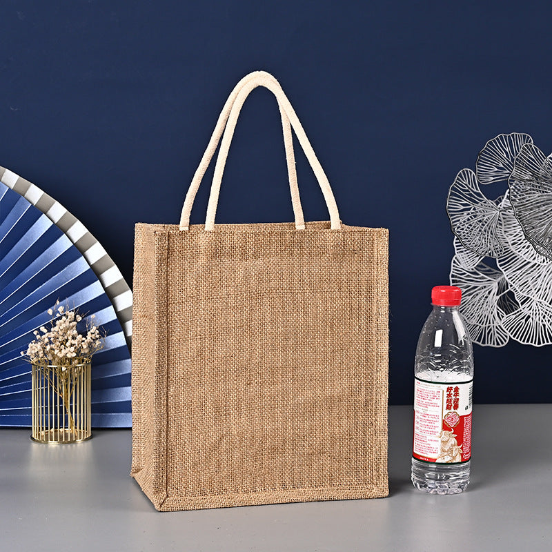 Brown jute bag with a bottle of water on a gray surface against a blue background