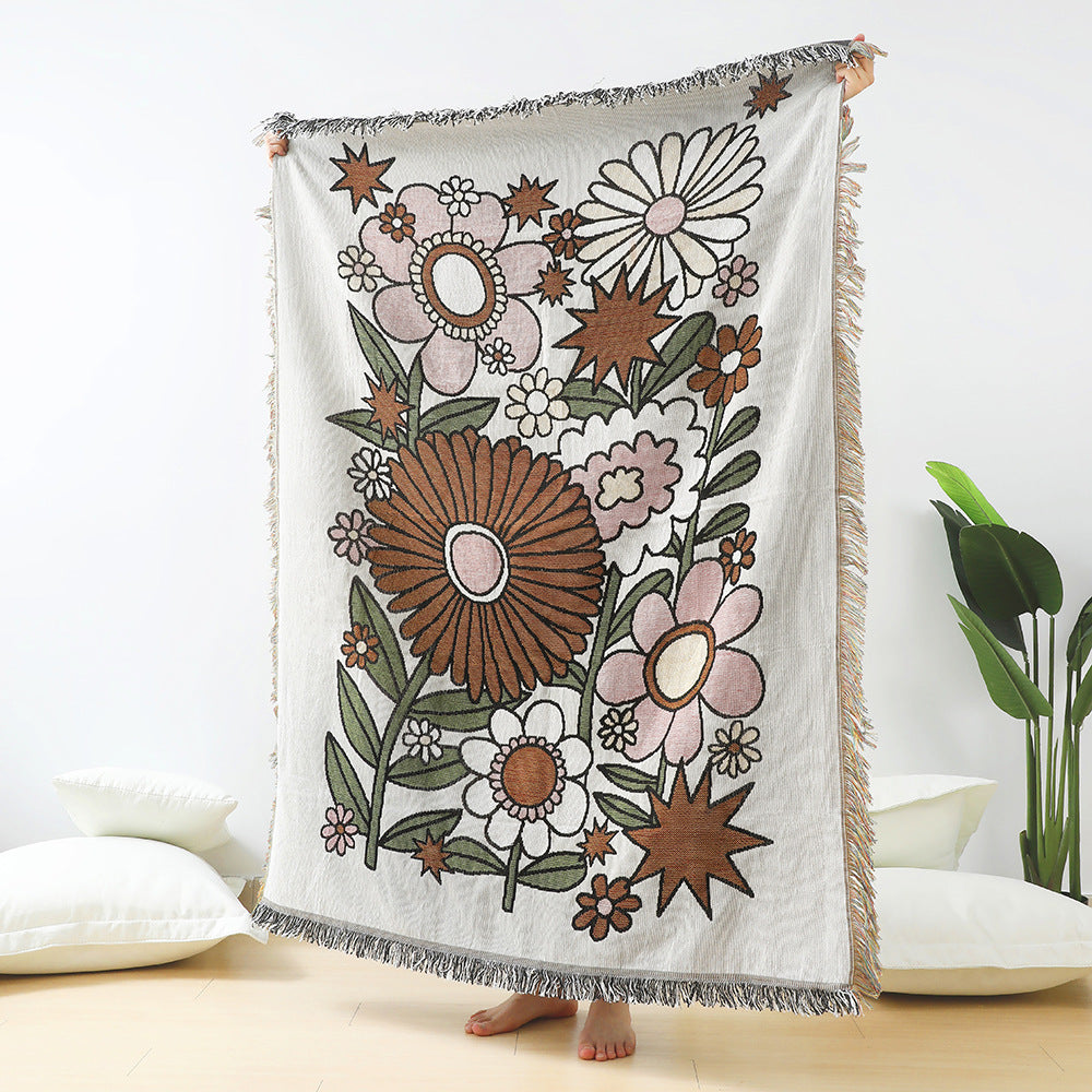Floral patterned throw blanket with fringe on a white background