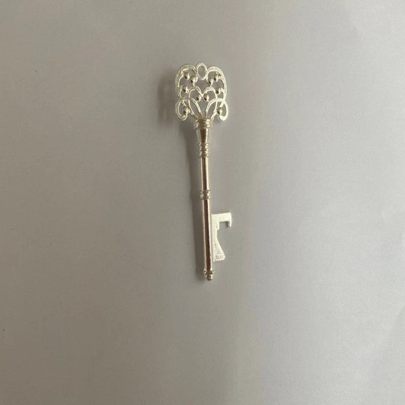 Decorative key with intricate design on a plain background