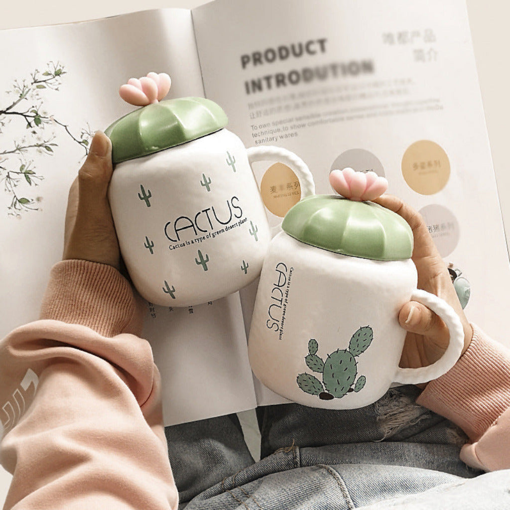 Two cactus-themed mugs held by hands with a product introduction sheet in the background.