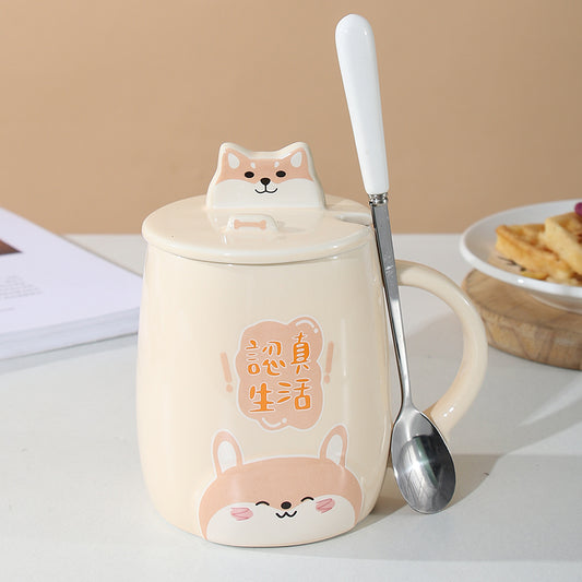 Ceramic mug with cartoon fox design, lid, and spoon on a table.