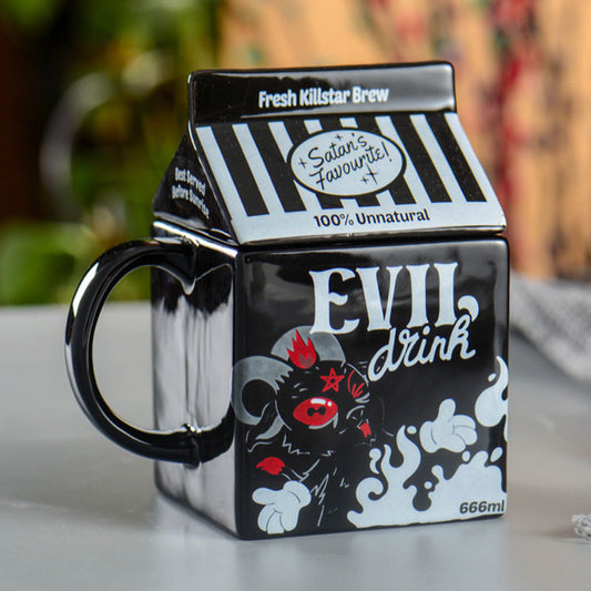 Black mug with 'Evil Drink' design and milk carton lid on a blurred background