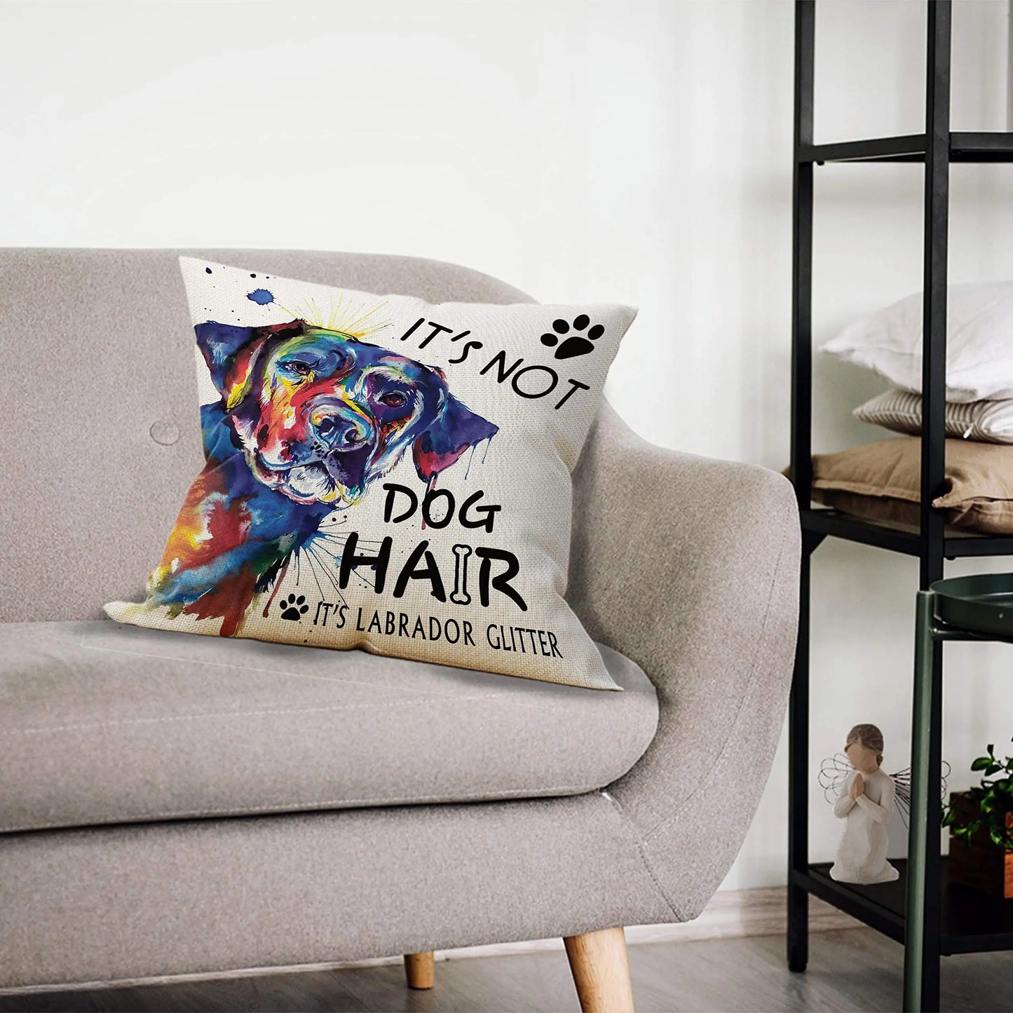 Decorative pillow with colorful dog illustration and text on a gray sofa.