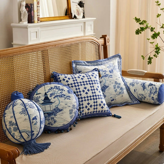 Set of blue and white patterned pillows on a wooden bench.