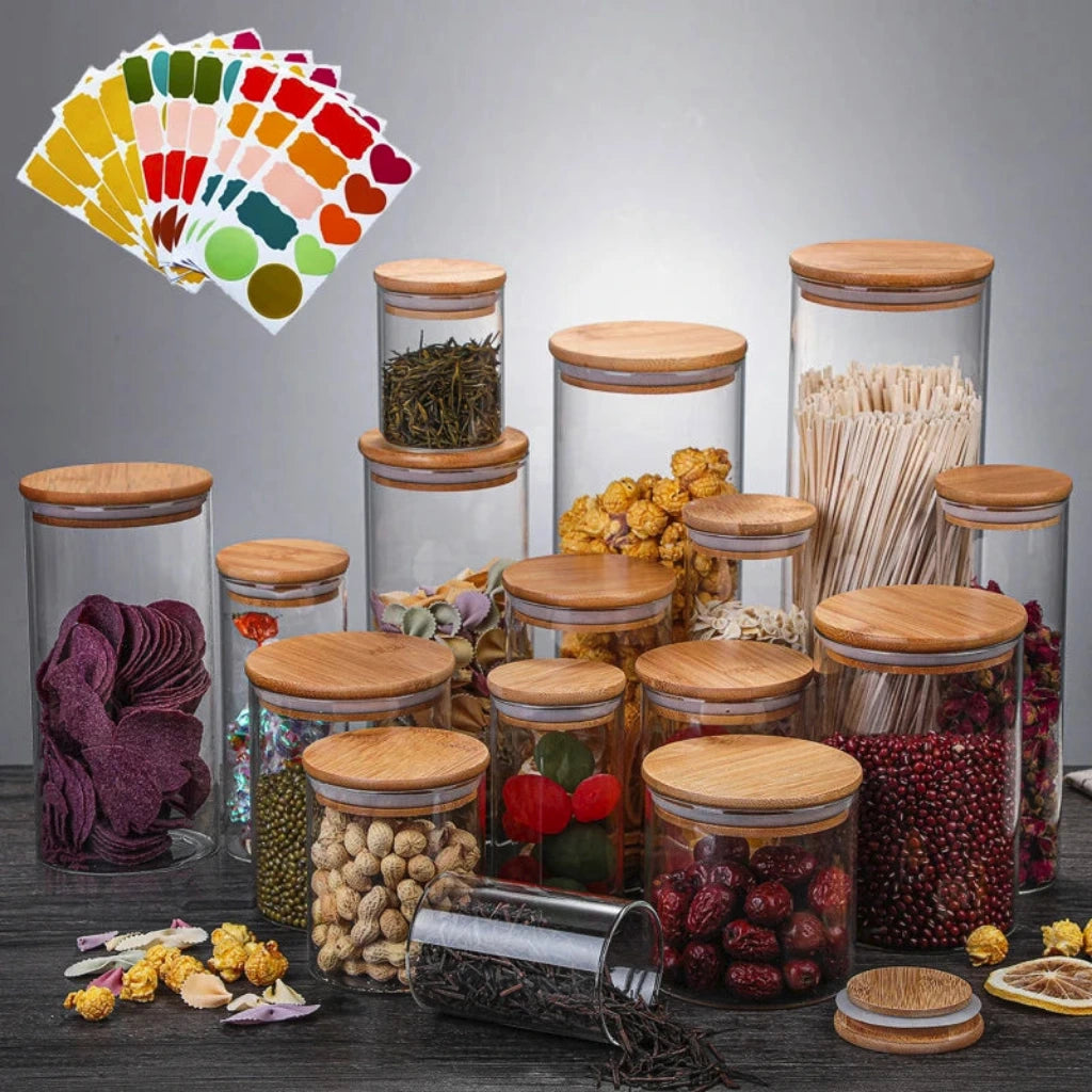 Set of glass jars with wooden lids containing various food items on a gray background.