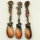Three ornate spoons with decorative handles on a white background