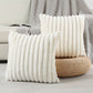 Two white textured pillows on a light-colored surface with a gray textured blanket in the background.